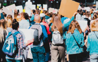 Protesters marching and waving signs at a rally